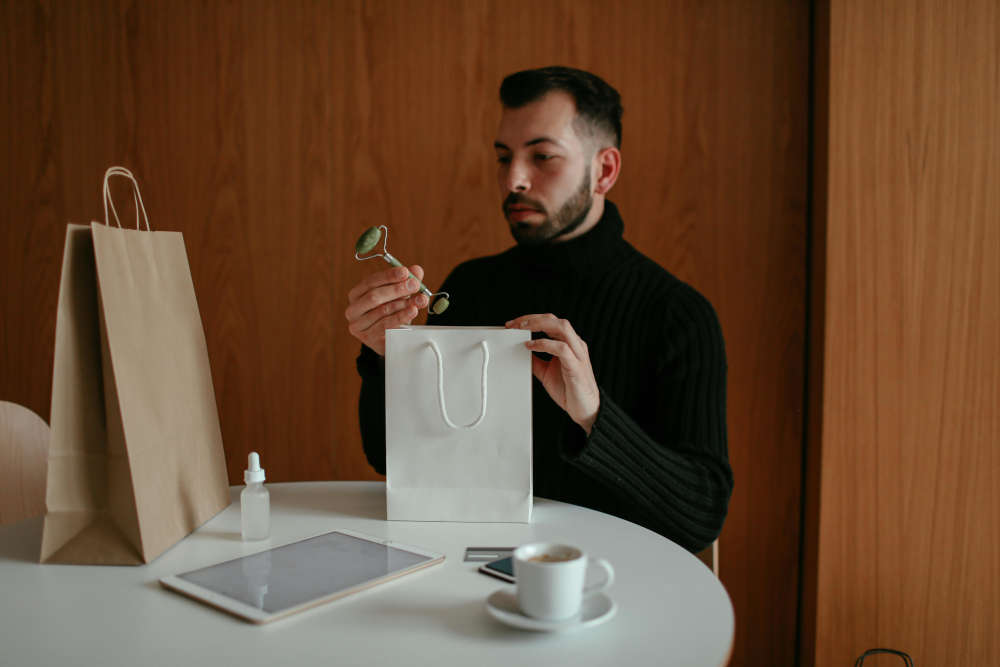 A man looking at a gift that he opened.